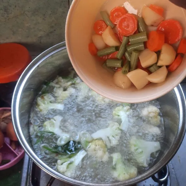 Masukkan irisan kentang, wortel dan buncis lalu masak sampai semua sayur matang.