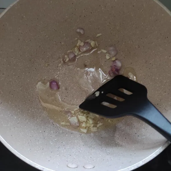 Tumis irisan bawang merah dan bawang putih.