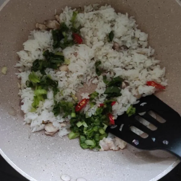 Masukkan nasi, sawi manis dan cabe rawit.