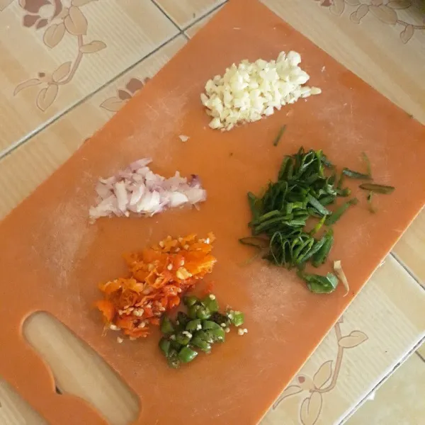 Iris halus bawang daun lalu cincang bawang merah, bawang putih, cabe rawit merah, dan cabe rawit hijau.