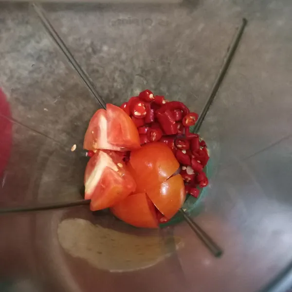 Potong-potong cabe merah keriting, bawang merah, bawang putih dan tomat, masukkan ke dalam blender.