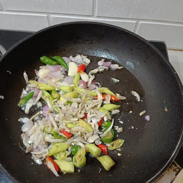 Masukkan irisan cabai dan teri nasi. Aduk merata sampai harum ikan asin.