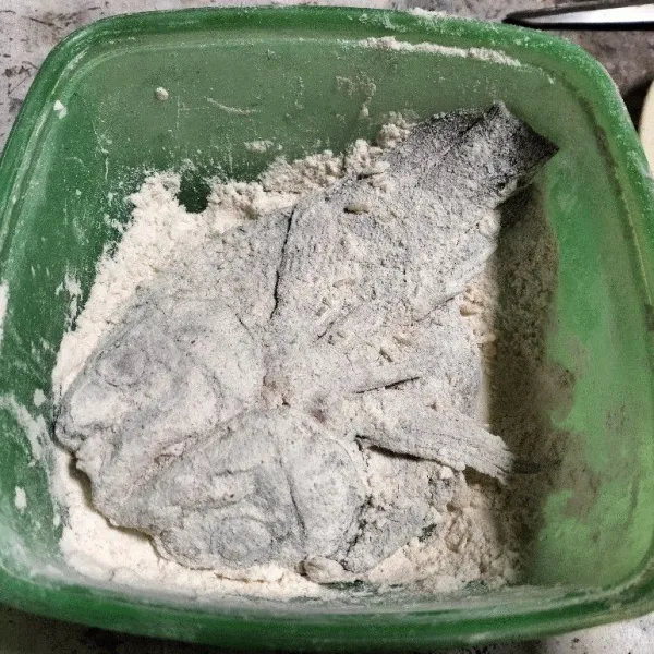 Siapkan tepung dengan mencampurkan bahan tepung bumbu. Lumuri ikan mujair tadi dengan tepung bumbu hingga tertutup seluruhnya.