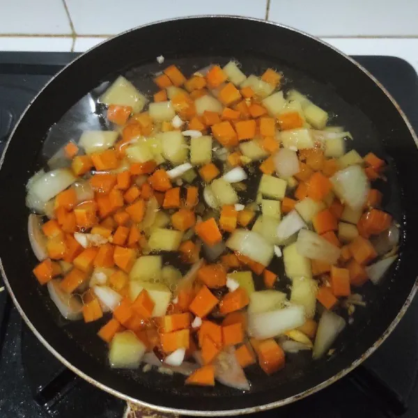 Masukkan kentang, wortel dan air lalu masak sampai empuk.