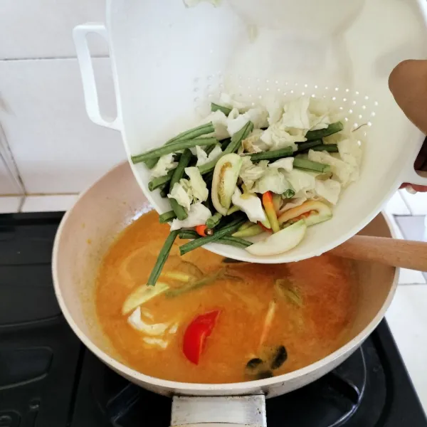 Masukkan sayuran dan cabai rawit utuh. Masak hingga sayur setengah matang. Bumbui dengan gula dan garam, lalu koreksi rasa