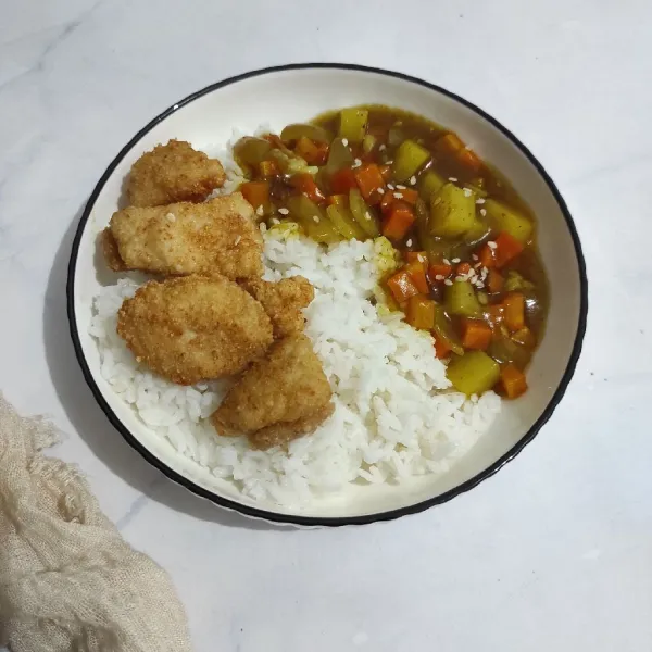 Sajikan chicken katsu dan curry sauce dengan nasi hangat, taburi dengan sedikit wijen.