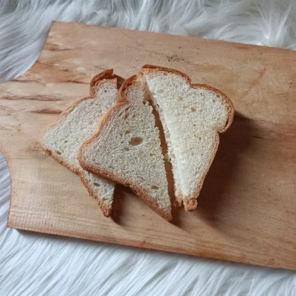 Potong roti tawar menjadi 2 dengan bentuk segitiga.