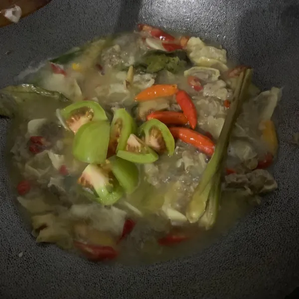 Tambahkan air, tomat hijau dan cabe rawit utuh.