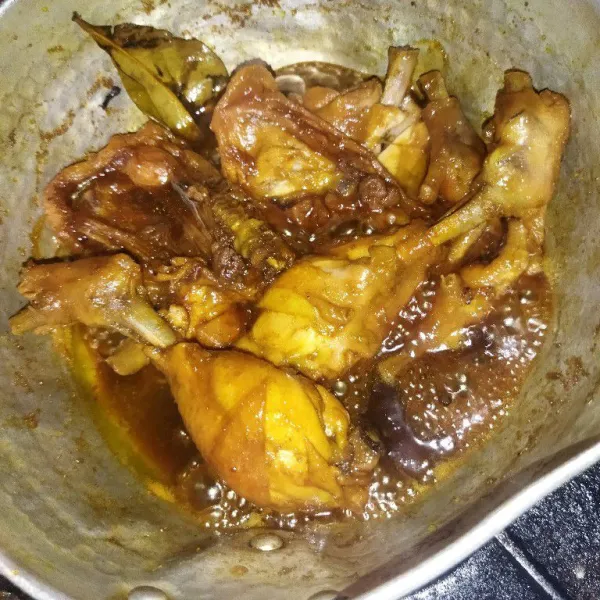 Lalu ungkep daging ayam hingga airnya menyusut dan agak mengental, lalu angkat daging ayam, daun salam, dan serai.