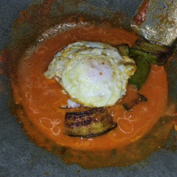 Masukkan telur dan terong yang sudah digoreng.