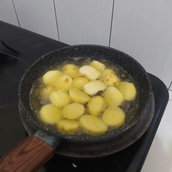 Kupas kentang, potong-potong lalu goreng hingga empuk.