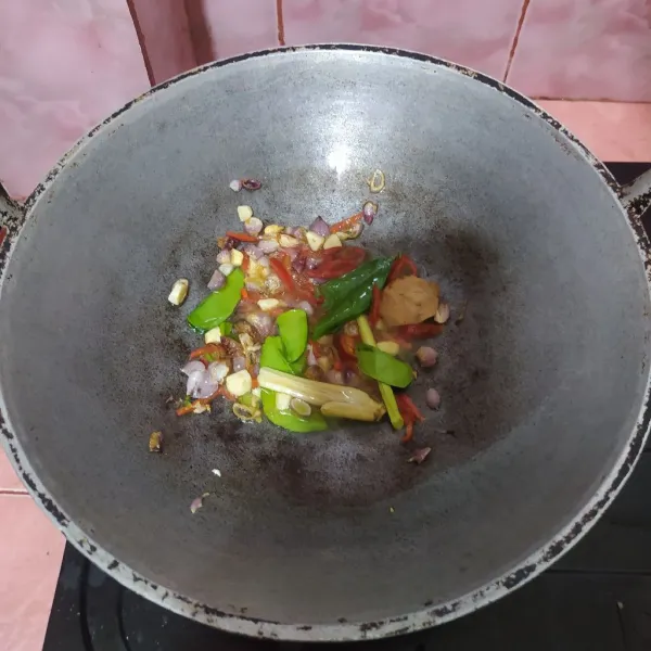 Tumis irisan bawang merah dan bawang putih lalu masukkan cabe merah. Beri serai, daun salam, lengkuas, daun jeruk.