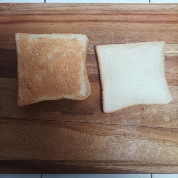 Oleskan selai kacang diatas roti, lalu tutup dengan lapisan roti lainnya.