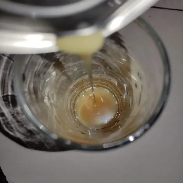 Masukkan susu kental manis ke dalam gelas.