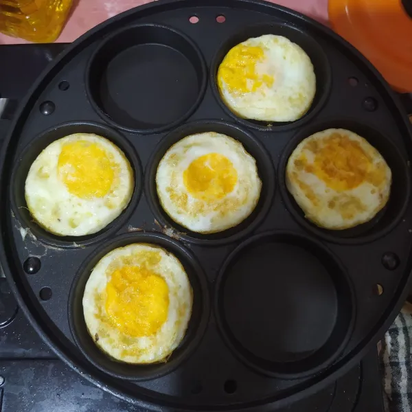 Panaskan cetakan martabak mini, olesi dengan minyak lalu masak telur ceplok.