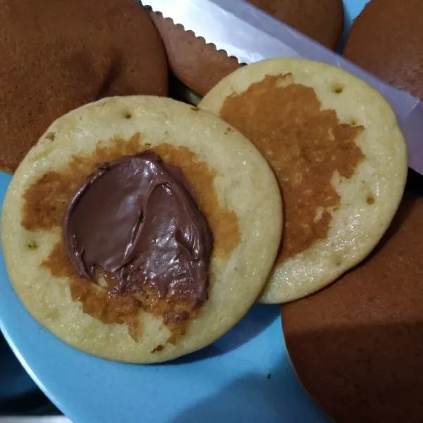 Kemudian oles dengan selai coklat atau pasta kacang merah, tutup dengan lembar dorayaki lainnya. Pijit pinggirannya agar rapat. Sajikan.
