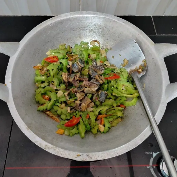 Masukkan ikan asin klotok, aduk rata. Masak hingga tanak lalu angkat.