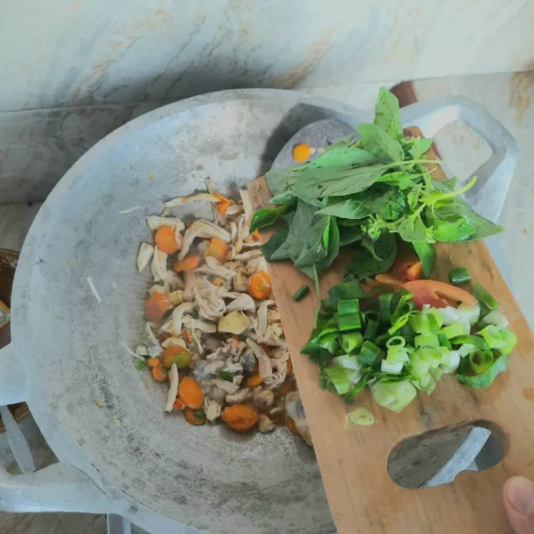 Masukan daun kemangi, bawang daun dan tomat, masak sampai layu, tes rasa. Ayam suwir kemangi siap disajikan.
