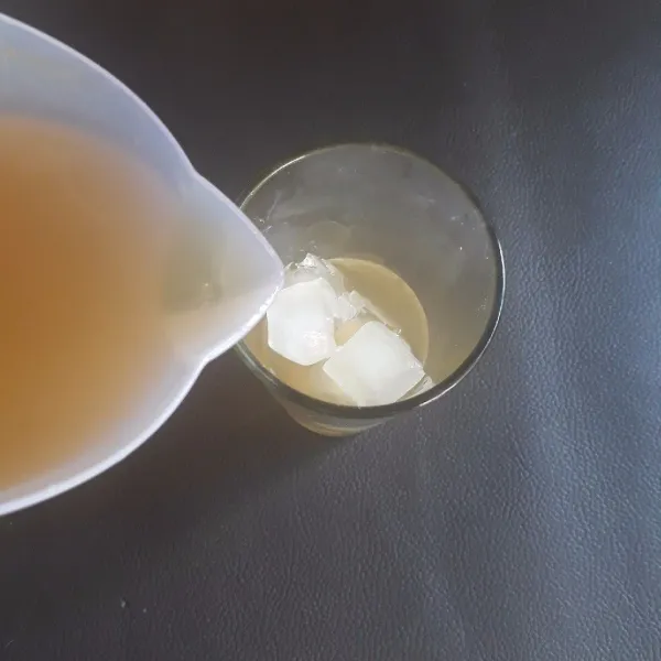 Masukkan es batu ke dalam gelas, tuangi dengan teh markisa, aduk rata dan sajikan.