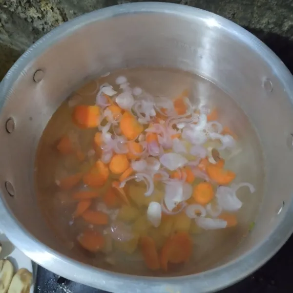Masukkan wortel dan kentang, rebus hingga setengah matang.
