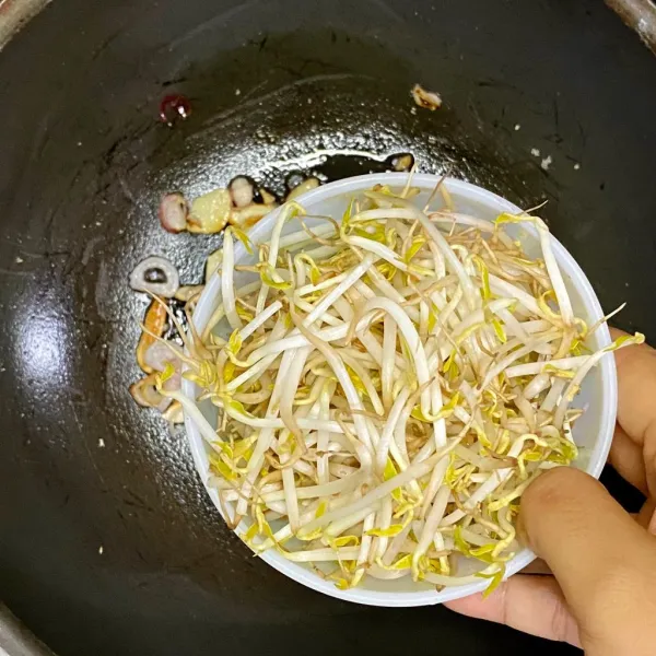 Tambahkan tauge, aduk-aduk hingga agak layu.