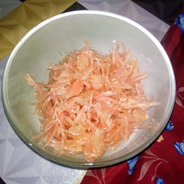 Siapkan pamelo/buah jeruk bali, dan pisah-pisahkan setiap bulirnya yang kemudian akan dipakai saat menyajikan