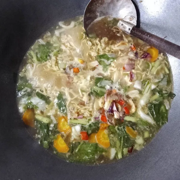 Masukan mie keriting, kecap, saos, dan bumbu ekstrak sapi. Tambahkan bawang dan cabe goreng.