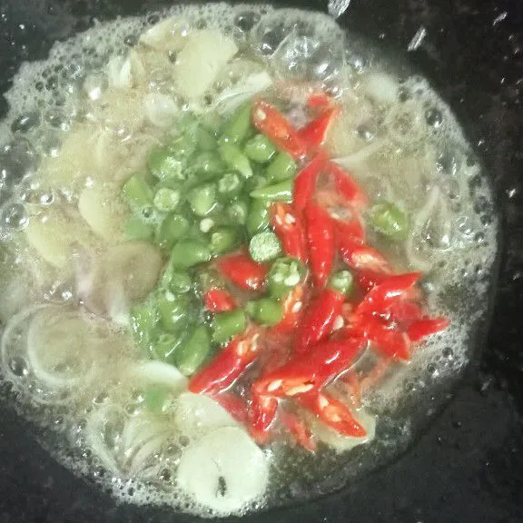 Lalu masukkan cabe merah dan cabe rawit, aduk rata tumis sampai cabe sedikit layu.