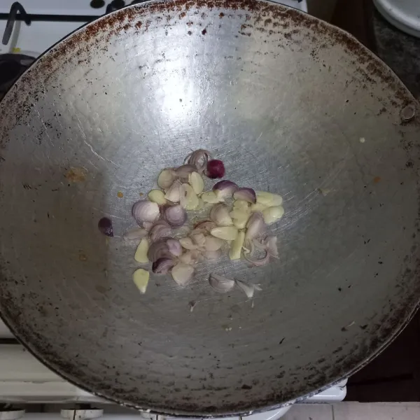 Tumis irisan bawang merah dan bawang putih hingga harum.