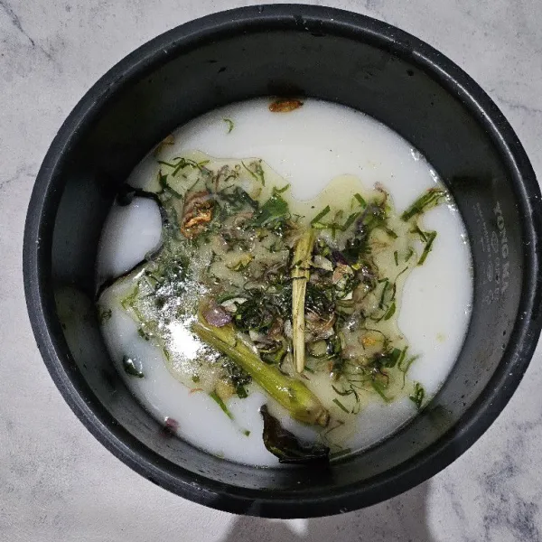 Tambahkan tumisan daun jeruk, aduk rata. Kemudian masak di dalam rice cooker.