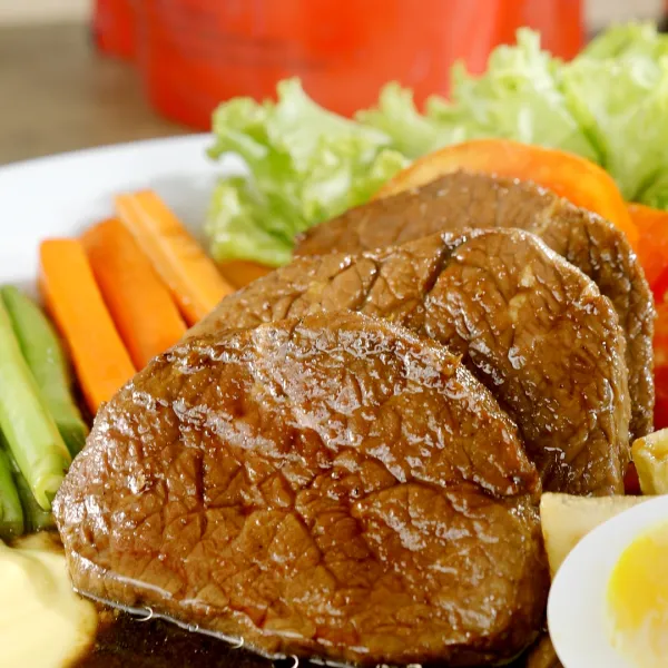 Potong daging kemudian sajikan dengan kentang, wortel, dan buncis yang sudah direbus dan mayones.