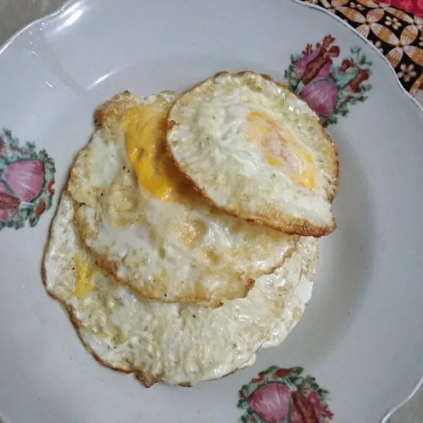 Goreng telur satu demi satu, lalu bumbui dengan sejumput garam.