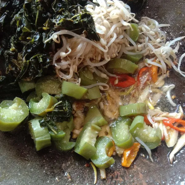 Masukkan rebusan daun pepaya jepang, terong dan taoge secara bersamaan, aduk rata.