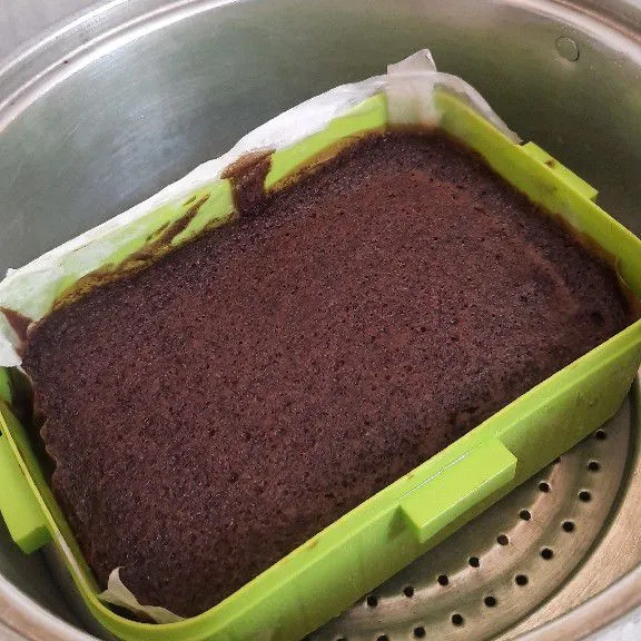 Olesi cetakan dengan mentega, lalu alasi kertas roti, lalu olesi dengan margarin lagi. Kukus adonan pertama 7 menit, lalu ditimpa adonan layer tengah 5 menit. Lanjut timpa adonan terakhir dan kukus 30 menit, jangan lupa tes tusuk