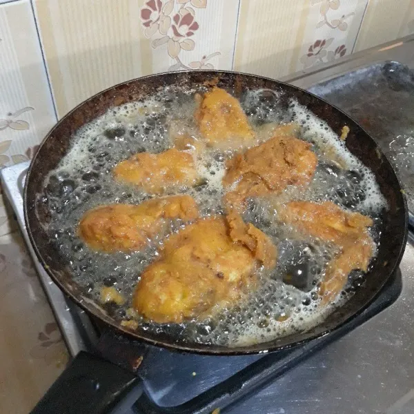 Setelah 30 menit, goreng sayap ayam di dalam minyak yang sudah dipanaskan hingga matang dan kecokelatan di kedua sisi lalu angkat dan tiriskan.