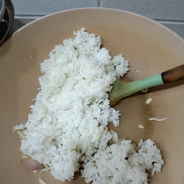 Masukkan nasi lalu aduk hingga bumbu tercampur merata.