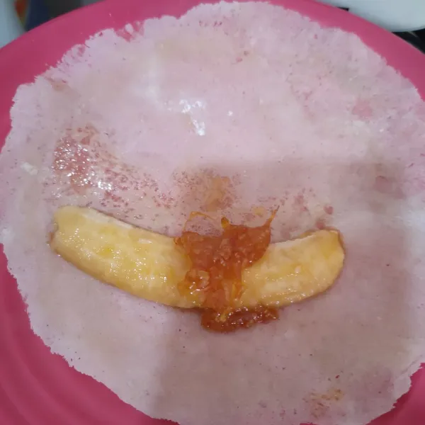 Cara membuat banh chuoi roll, siapkan kulit lumpia beri pisang karamel, kemudian gulung