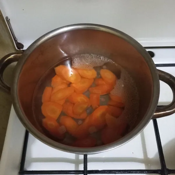 Didihkan air secukupnya pada panci, masukkan irisan wortel.