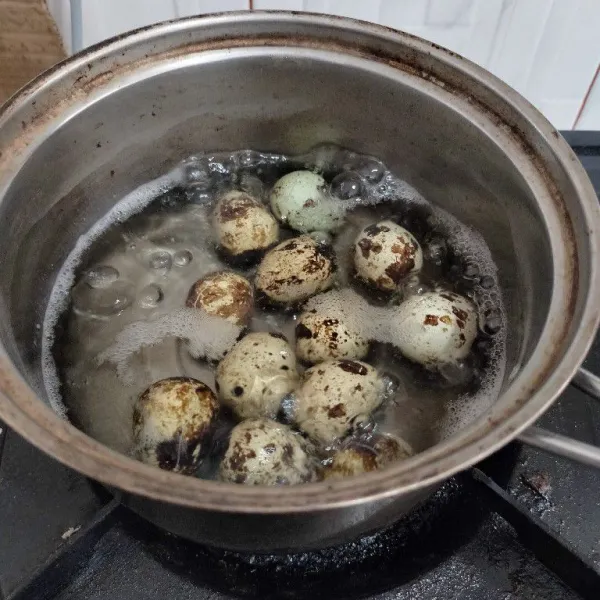 Rebus telur puyuh hingga matang.
