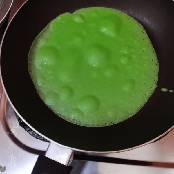 Panaskan wajan teflon anti lengket. Oles dengan sedikit minyak goreng dengan menggunakan tisu. Oles tipis-tipis saja lalu tuang adonan 1 sendok sayur, buat gerakan melingkar. Setelah itu, tunggu sampai pinggir-pinggir kulit dadarnya kering lalu angkat. Lakukan sampai adonan habis.
