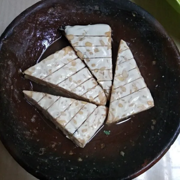 Masukkan potongan tempe, rendam selama 5 menit.