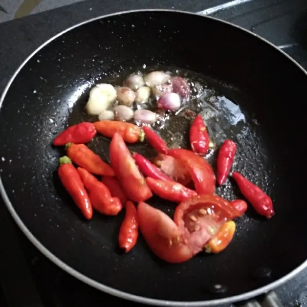 Masukkan cabe dan tomat merah, masak sampai matang.