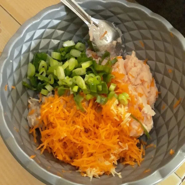 Tambahkan parutan wortel, parutan bawang putih dan potongan daun bawang, aduk rata.