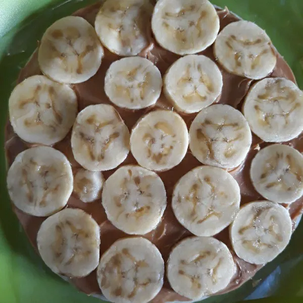 Susun pisang di tengah sampai penuh di atas kulit pizza.