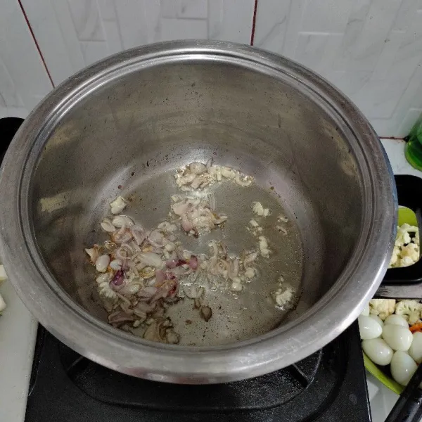 Panaskan minyak lalu tumis duo bawang hingga harum.