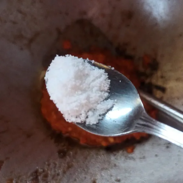 Pindahkan sambal ke dalam wajan, kemudian bumbui dengan garam, gula, dan kaldu jamur