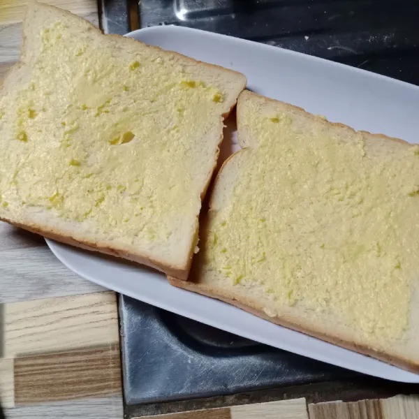 Oleskan campuran gula dan margarin pada permukaan roti.
