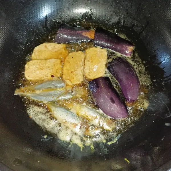 Kemudian goreng ikan, tempe dan terong sampai matang.