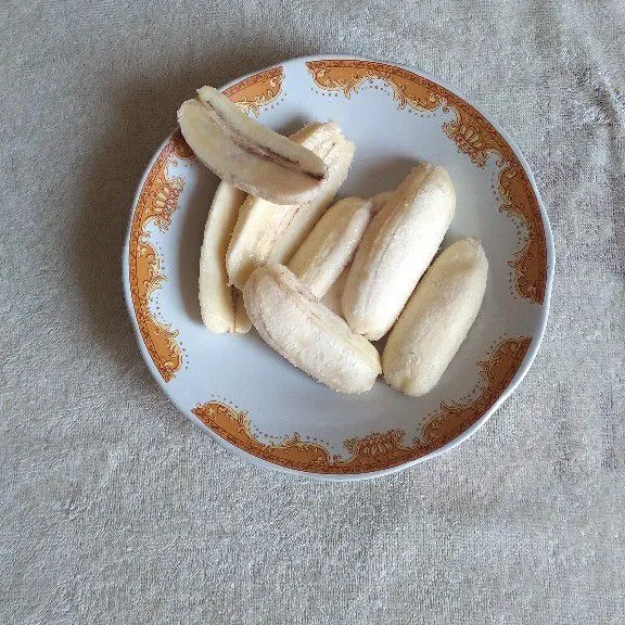 Belah setiap pisang menjadi 2 bagian.
