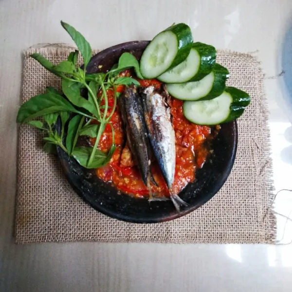 Masukkan ikan keranjang, tekan-tekan dengan ulekan. Sajikan dengan daun kemangi dan timun.